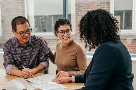 people filling out mortgage paperwork at a desk