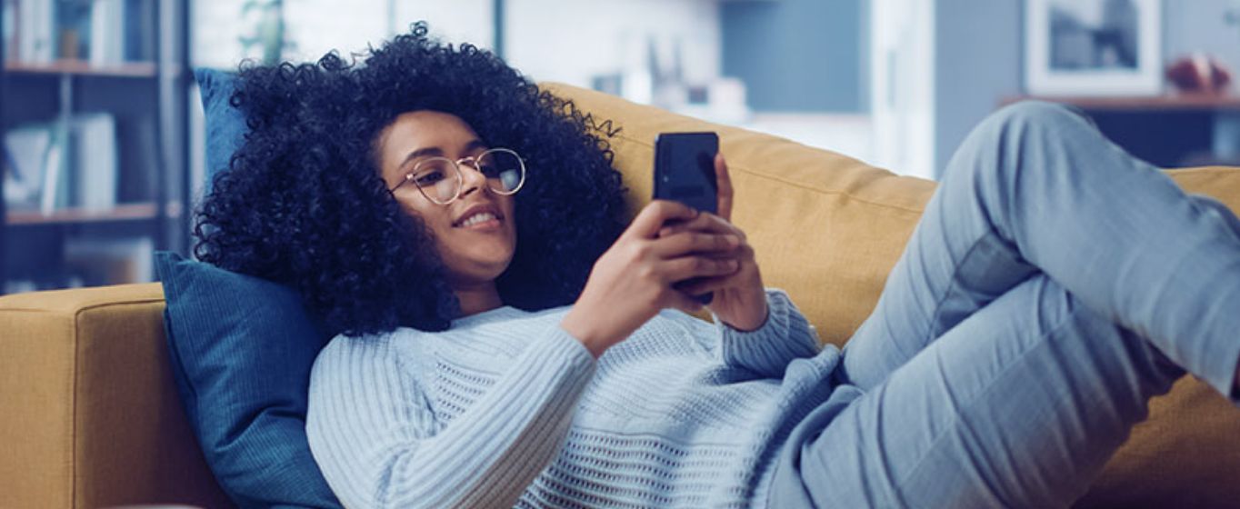 Woman on her mobile phone while on couch