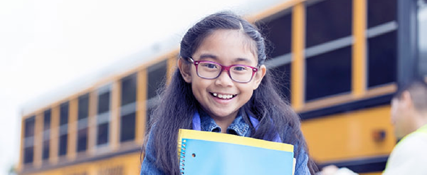 Young girl getting off a school bus