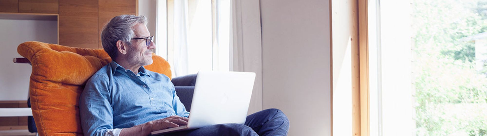 older man on his laptop in his home