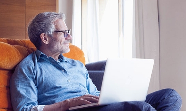 older man on his laptop in his home