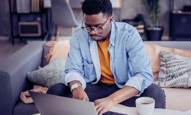 Young man looking on his laptop for debt consolidation loans