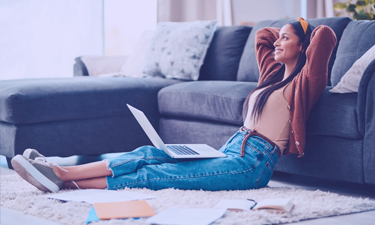 Woman relaxing on the floor looking at her laptop