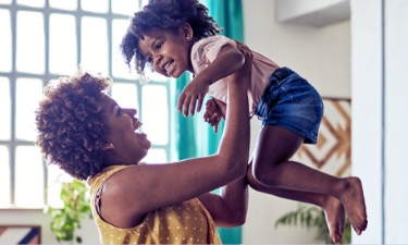 mother holding daughter inside their home