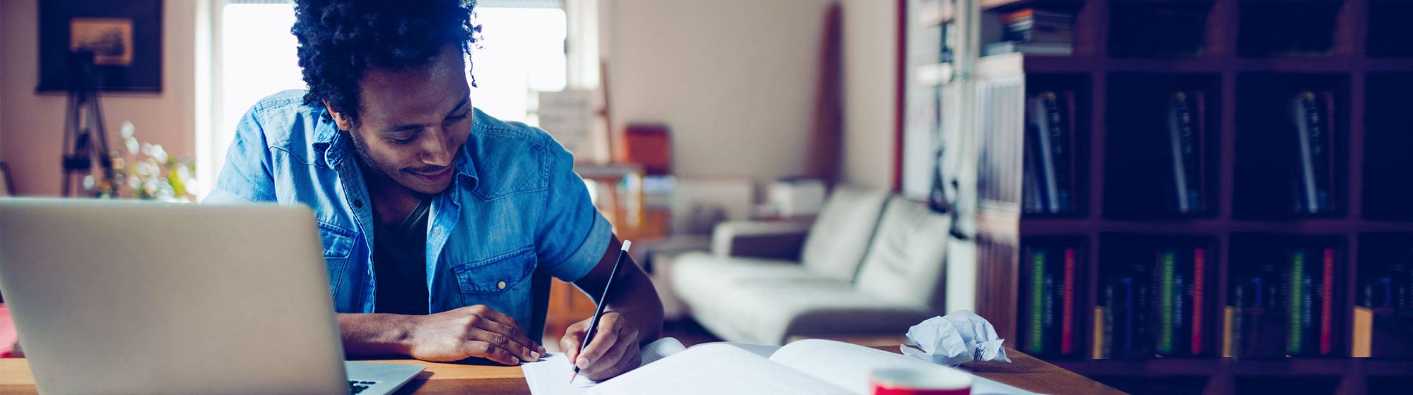 young student taking notes in his room