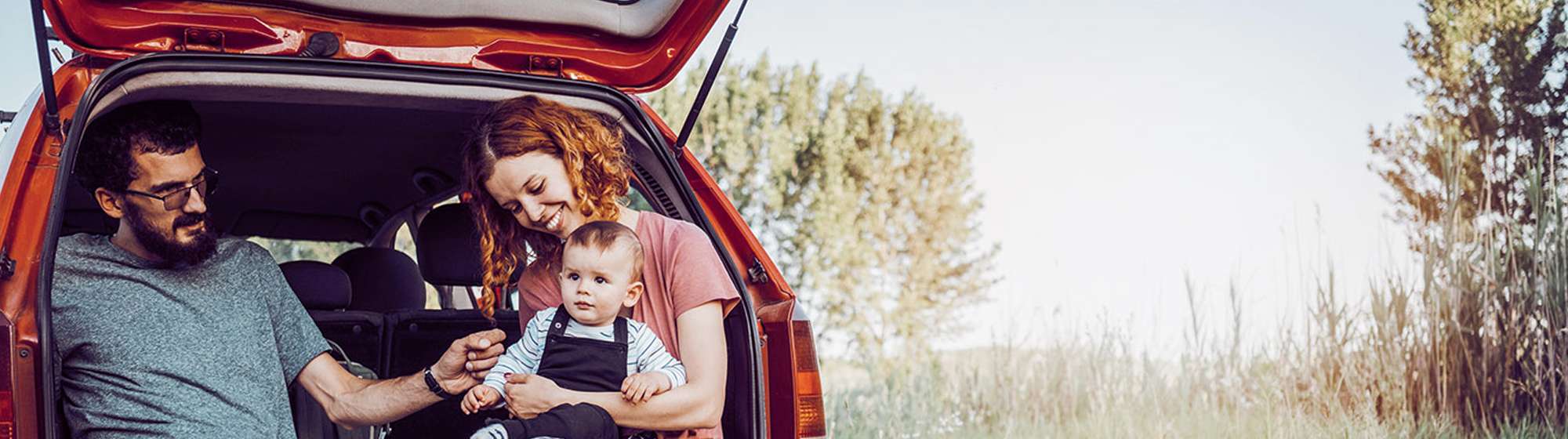 father, mother and son sitting in the car