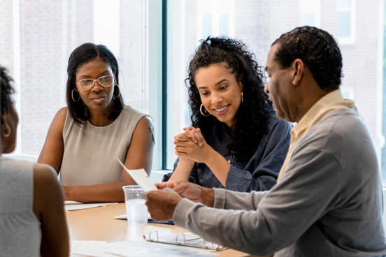 The mature adult reviews the retirement documents as he leads a meeting with a team employees.